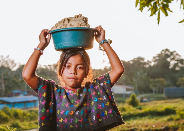 Q'eqchi girl holding a basket of corn in Guatemala, where most Q'eqchi interpreters live.